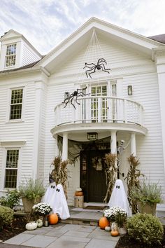 a white house decorated for halloween with pumpkins and decorations