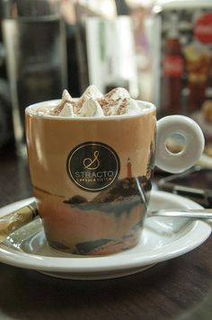 a coffee cup with marshmallows in it on a saucer