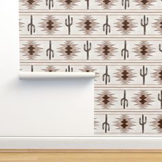 a white wall with a brown and beige pattern on it, next to a wooden floor