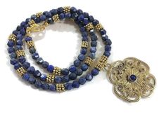 This lapis necklace is made of a gold plated and lapis pendant, faceted navy blue lapis lazuli gemstones, gold plated:  daisy spacers, lobster claw clasp and findings.  This necklace measures 25 3/4 inches in length and the pendant is 1 1/2 inches. The ancient Romans used lapis as an aphrodisiac. Lapis lazuli is said to help stimulate emotional, mental, and physical purity and clarity. The ancient Egyptians used lapis for protection. All of our jewelry is unique and custom designed. Most of our Elegant Gold Beaded Necklaces With Lapis Lazuli, Gold Lapis Lazuli Faceted Beads Necklace, Gold Lapis Lazuli Necklace With Faceted Beads, Bohemian Gold Lapis Lazuli Necklace, Gold Lapis Lazuli Jewelry With Polished Beads, Traditional Gold Lapis Lazuli Jewelry, Traditional Gold Jewelry With Lapis Lazuli, Gold Lapis Lazuli Necklaces For Jewelry Making, Gold Necklaces With Lapis Lazuli Gemstone Beads