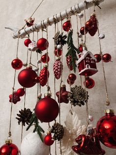 an assortment of christmas ornaments hanging from a ceiling fixture with white and red baubles