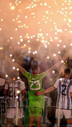 the soccer players are celebrating with their arms in the air as fireworks go off behind them