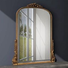 a mirror sitting on top of a mantle next to a window