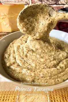 a bowl filled with hummus and cheese on top of a table