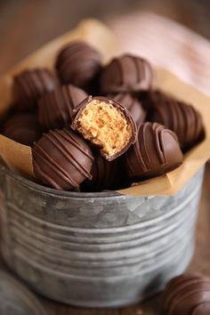 a tin filled with chocolate covered candies on top of a wooden table