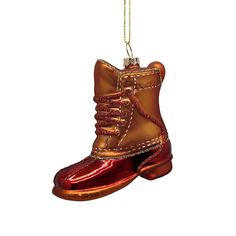 an ornament shaped like a boot hanging from a chain on a white background