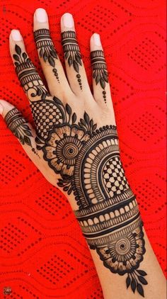 a woman's hand with henna tattoos on it