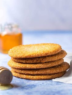 a stack of cookies sitting on top of a table next to a jar of honey