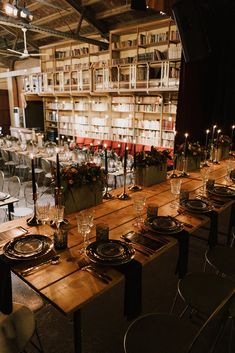 a long wooden table with plates and glasses on it