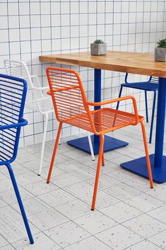 two chairs and a table in front of a tiled wall