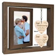 a wooden heart shaped photo frame with two hearts attached to it and an engraved keychain hanging from the front