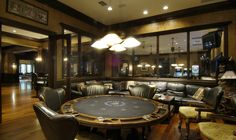 a casino table in the middle of a room with leather chairs and tables around it