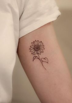 a woman's arm with a tattoo on it that has a sunflower in the center