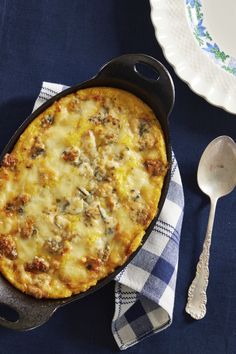 a casserole dish with cheese and meat in it on a blue table cloth