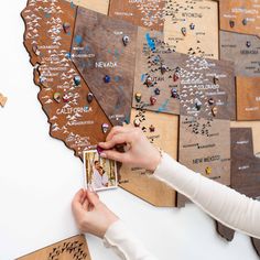 a person placing pins on a wooden state map