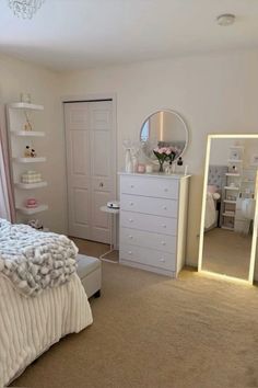 a bedroom with a bed, dresser and large mirror in front of the closet door