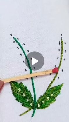 someone is stitching a flower on a piece of fabric with a needle and thread