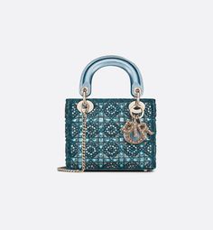 The Lady Dior bag epitomizes Dior's vision of elegance and beauty. It demonstrates the House's unique leather craftsmanship and is offered in celestial blue satin, embroidered with a multitude of beads in a hallmark Cannage-motif design, while the handles are made with tonal metallic lambskin. Pale gold-finish metal D.I.O.R. charms are adorned with white crystals and further embellish its silhouette. The miniature style, with its removable chain shoulder strap, can be carried by hand or worn cro Lady Dior Mini, Tas Lv, Mini Lady Dior, Christian Dior Bag, Celestial Blue, Pearl Embroidery, Womens Designer Bags, Small Lady, Christian Dior Couture