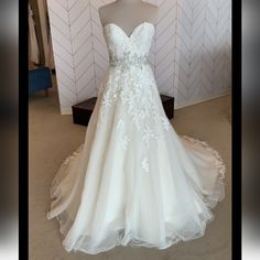 a wedding dress on display in front of a wall