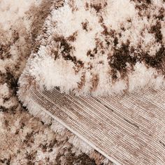 an area rug with brown and white carpeting on top of it, in close up view