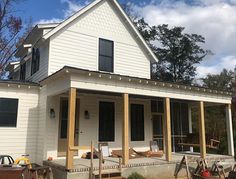 a white house with lots of wood on the front porch