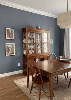 a dining room with blue walls and wooden furniture