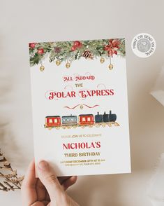 a hand holding up a card with an image of a train on it and the words polar express