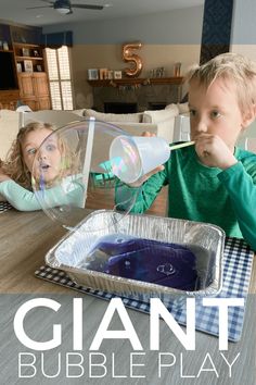 two children sitting at a table with bubble play