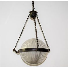 a light fixture hanging from a chain on a wall