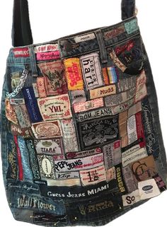 a handbag made out of old jeans with patches and stickers all over it