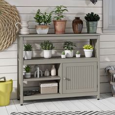 a shelf with potted plants on top of it