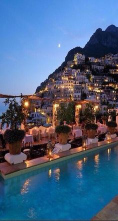 an outdoor swimming pool with tables and chairs next to it