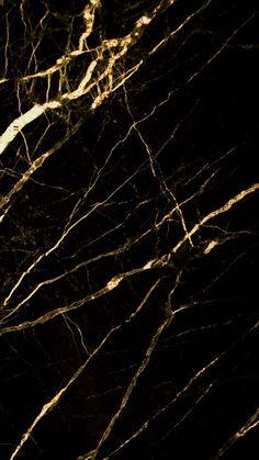 a black and gold marble textured wallpaper with light streaks on the top part of it