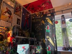 a room filled with toys and posters on the wall next to a window covered in magnets