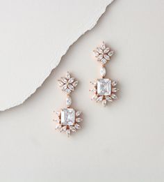 "Rose gold cubic zirconia earrings in a stunning Art Deco style are a perfect addition to your wedding day or special occasion. Created with Swarovski pure Brilliance stones in rose gold, yellow gold or rhodium finish. Earrings measure 1.875\" x .875\" Back to my shop: https://www.etsy.com/shop/TheExquisiteBride?ref=l2-shopheader-name" Rose Gold Diamond Crystal Earrings For Wedding, Rose Gold Cubic Zirconia Diamond Earrings For Wedding, Glamorous Rose Gold Cubic Zirconia Bridal Earrings, Rose Gold Diamond Bridal Earrings For Wedding, Glamorous Rose Gold Cubic Zirconia Chandelier Earrings, Rose Gold Elegant Diamond Earrings For Wedding, Dazzling Rose Gold Cubic Zirconia Bridal Earrings, Dazzling Rose Gold Wedding Earrings, Dazzling Rose Gold Bridal Earrings