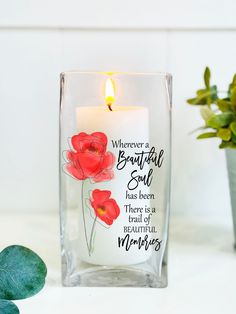 there is a candle that has been placed in a vase with some flowers on it