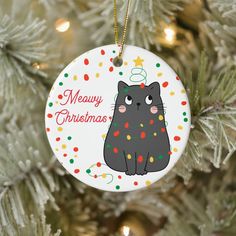 a christmas ornament with a black cat on it's back hanging from a tree