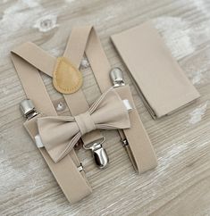 Your special guy will look so handsome when he shows up in his Biscotti / Frost Tan bow tie, pocket square and Champagne Tan suspenders!  Great set for groomsman, best man or ring bearers - This bow tie & suspenders set is a great choice for family photos, wedding, ring bearer outfit, birthday celebration or any other special occasion.  When making a purchase, you can choose from the following options : -Suspenders Only -Bow Tie Only. -Suspenders + Bow Tie Set. - Pocket Square only. -3 Pieces Se Dapper Suspenders For Wedding, Dapper Wedding Suspenders, Tan Bow Tie, Bearer Outfit, Ring Bearer Outfit, Bowtie And Suspenders, Suspenders Set, Bow Tie Set, Wedding Bows