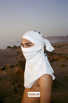 a woman wearing a white head covering over her face with the word cold on it