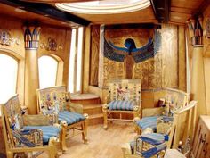 an egyptian themed living room with blue and gold decor on the walls, wood floors and ceiling