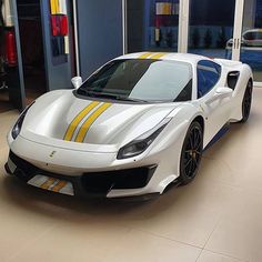 a white and yellow sports car in a showroom