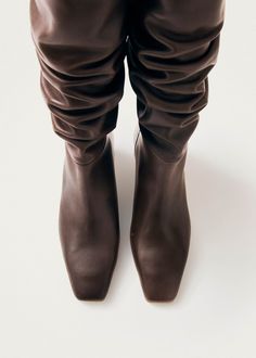 Brown leather high-knee boots with kitten heels In a word: attitude. The Kalila are knee-high boots crafted from brown leather, featuring elongated square toes and fine kitten heels that ensure comfort for all-day wear. Their dramatic wrinkled effect on the shafts adds a striking flair that will steal the spotlight in any look. Brown Leather Boots, Samoa, Sierra Leone, Seychelles, Guinea Bissau, Papua New Guinea, British Indian, Mozambique, A Word