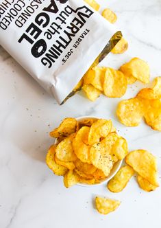 a bag of potato chips sitting on top of a counter next to a pile of chips