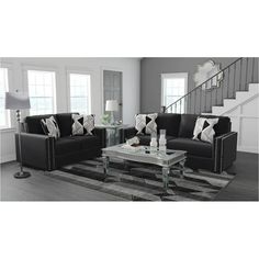 a black and white living room with two couches, a coffee table and a stair case