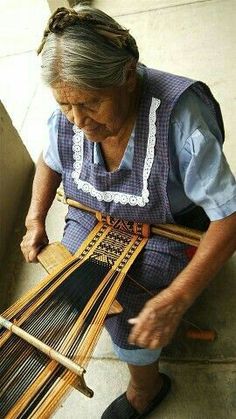 an old woman weaving on a loom with her hands