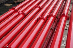 red pipes are lined up on the ground