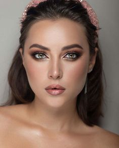 a woman wearing a pink headband with pearls on it's hair and eyes