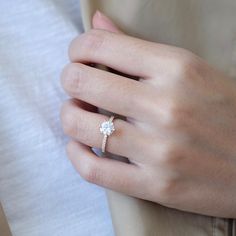 a woman's hand with a diamond ring on it