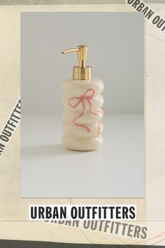 a soap dispenser with pink ribbon on it and the words urban outfitters written below