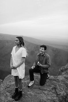 two people sitting on top of a mountain